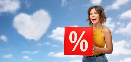 shopping, consumerism and people concept - happy smiling young woman in mustard yellow top and jeans...