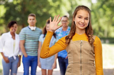 gesture, friendship and people concept - happy smiling young teenage girl in mustard yellow top...