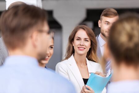 people, work and corporate concept - business team with meeting and talking at office building