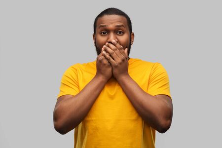 scared african american man covering his mouth