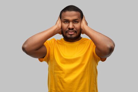 stressed man closing his ears with hands