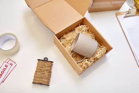 parcel with straw filler and mug at post office