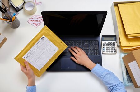 hands with laptop and envelope at post officeの写真素材