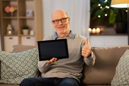 happy senior man with tablet computer at homeの写真素材