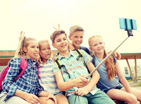happy elementary school students taking selfieの写真素材