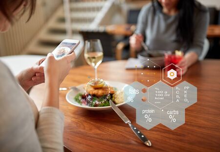 hands with phone and food nutritional value chart