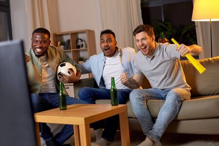 friends with ball and vuvuzela watching soccer
