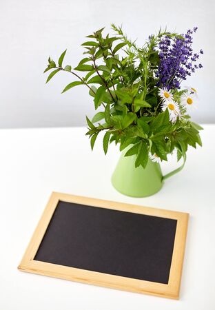 bunch of herbs and flowers with chalkboardの写真素材
