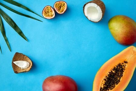food, summer and healthy eating concept - different exotic fruits on blue background