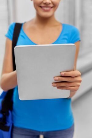 education, technology and people concept - close up of student woman with bag and tablet computerの写真素材
