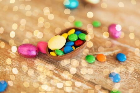 chocolate egg and candy drops on wooden table
