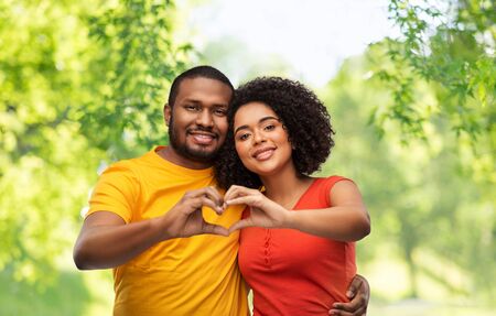 happy african american couple making hand heartの写真素材