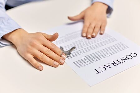 realtors hands with keys and contract on table