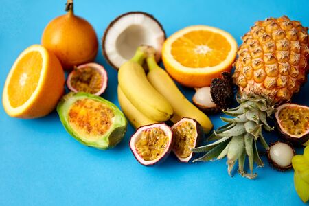 food, summer and healthy eating concept - different exotic fruits on blue backgroundの写真素材