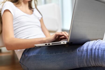 education, technology and people concept - close up of teenage student girl with laptop and books at...
