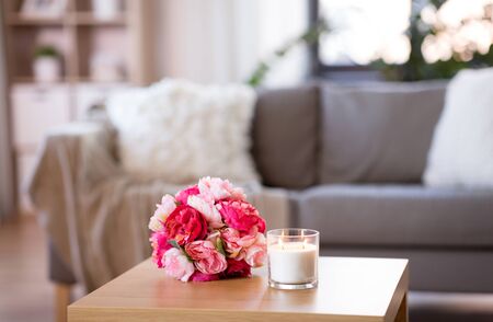 burning fragrance candle and flower bunch at homeの写真素材