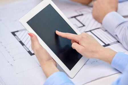 architects with tablet pc and blueprint at office