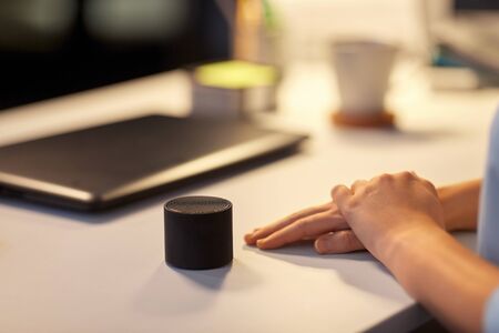 close up of hand with smart speaker at officeの写真素材