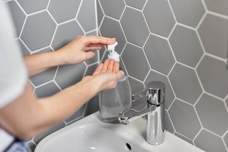 close up of woman washing hands with liquid soap