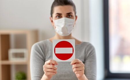woman in protective medical mask showing stop sign
