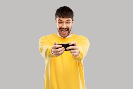happy laughing young man with smartphone