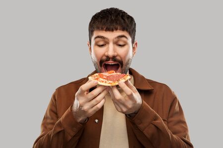 hungry young man eating pizza
