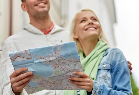 close up of happy couple with map exploring city