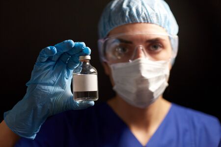 close up of doctors hand with bottle of medicine