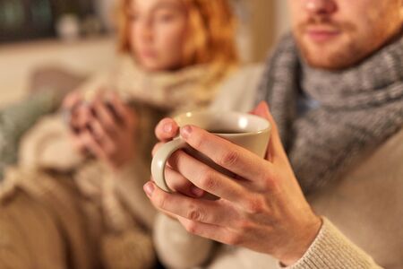 close up of sick young couple drinking tea at homeの写真素材
