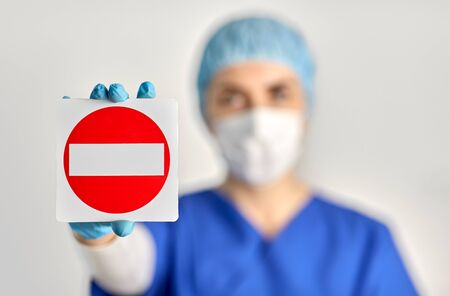doctor or nurse in face mask showing stop signの写真素材