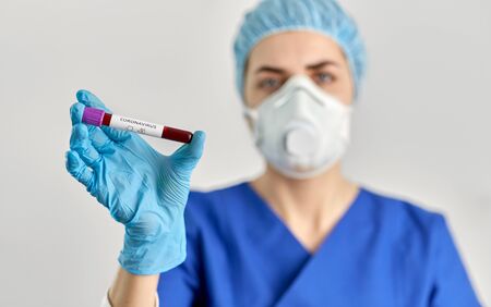 doctor holding beaker with coronavirus blood test