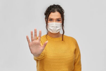 health protection, safety and pandemic concept - portrait of young woman in protective medical face...
