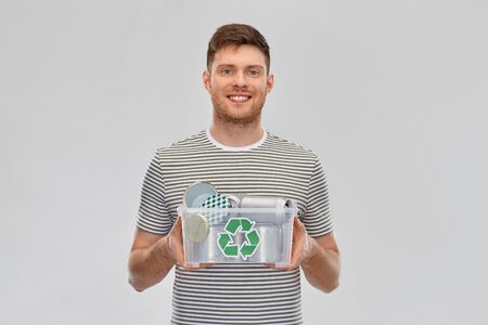 smiling young man sorting metallic wasteの写真素材