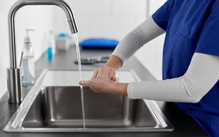 doctor or nurse washing hands with liquid soap