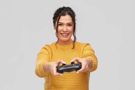 gaming, entertainment and people concept - portrait of happy smiling young woman with pierced nose...