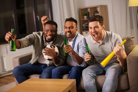 friends or soccer fans with ball and beer at home