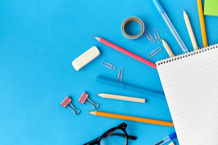 notebook and school supplies on blue backgroundの写真素材