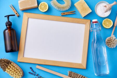 sustainability and eco living concept - natural cleaning supplies around white board on blue backgroundの写真素材