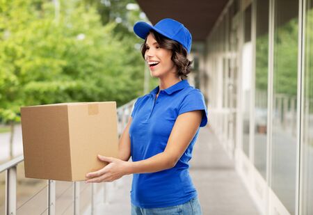 happy delivery girl with parcel box in blueの写真素材