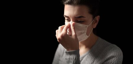 sick woman adjusting protective medical face maskの写真素材