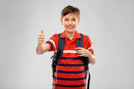 happy student boy with backpack showing thumbs upの写真素材