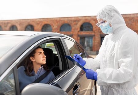 healthcare worker with clipboard and woman in car