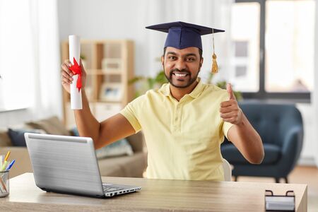 indian student with laptop and diploma at homeの写真素材