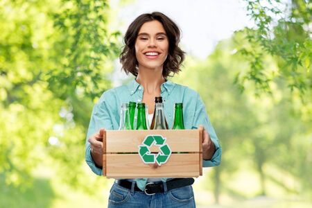 smiling young woman sorting glass wasteの写真素材