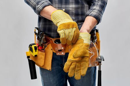 builder with working tools putting gloves onの写真素材