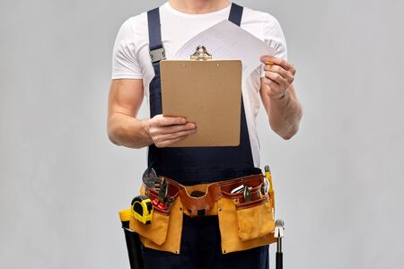 builder with clipboard, pencil and working toolsの写真素材