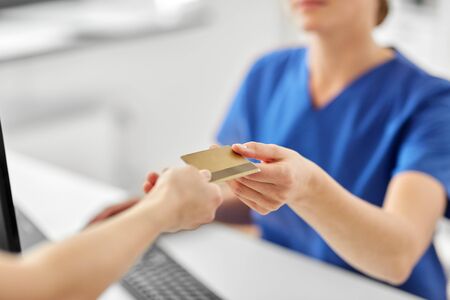 medicine, people and healthcare concept - close up of patient giving female doctor or nurse...