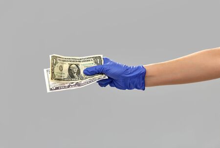 close up of hand in medical glove with moneyの写真素材