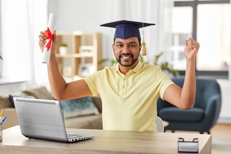 indian student with laptop and diploma at homeの写真素材