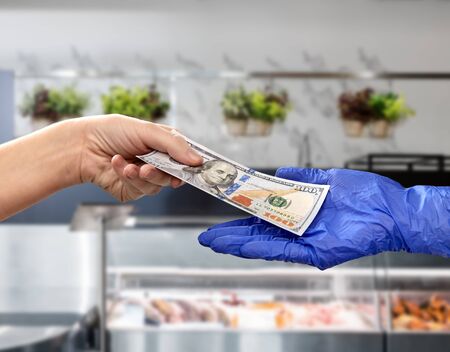 close up of hand in medical glove giving money